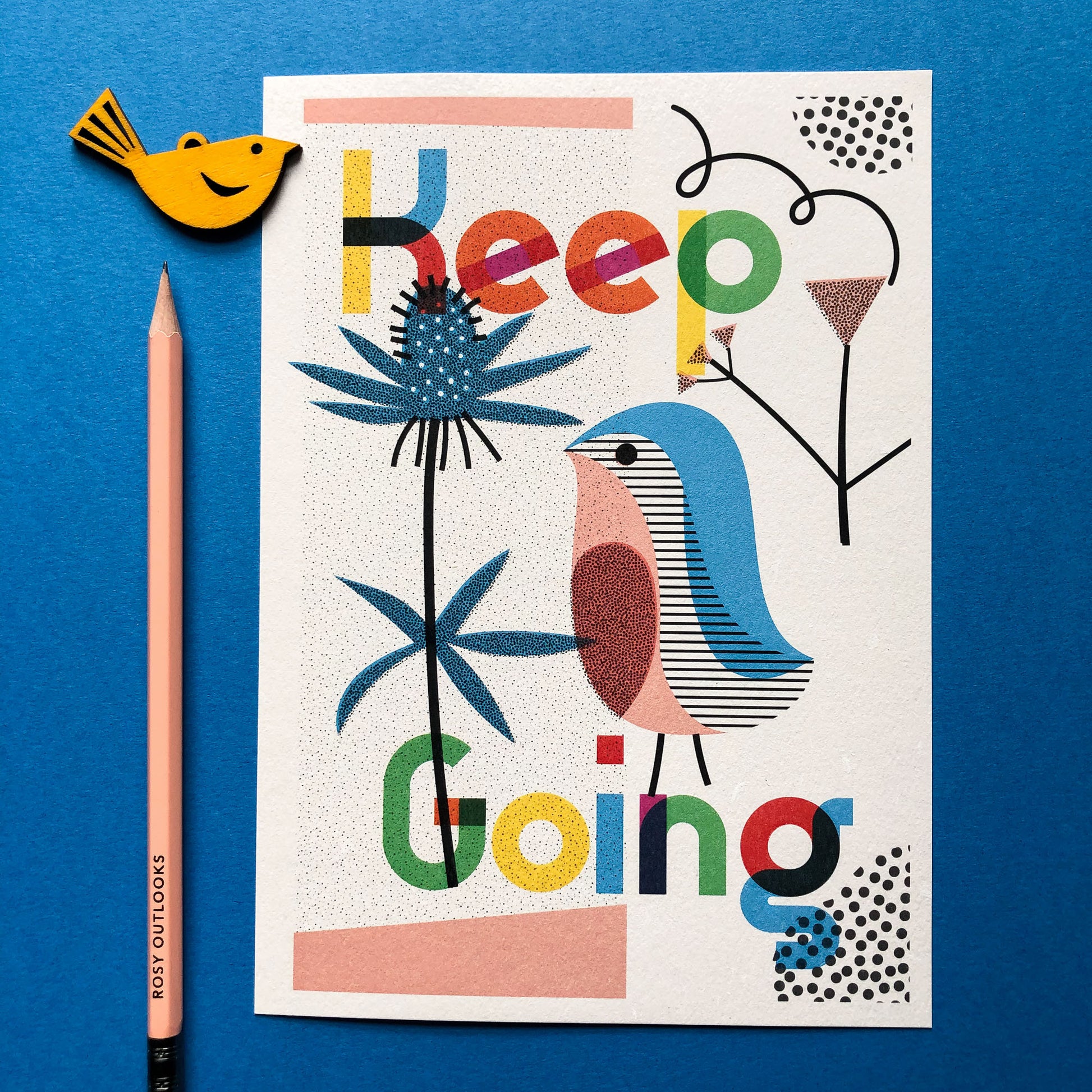A4 Keep Going Art Print by The Print Lass. Shown unframed on a blue background with a pencil and small wooden bird (not included)